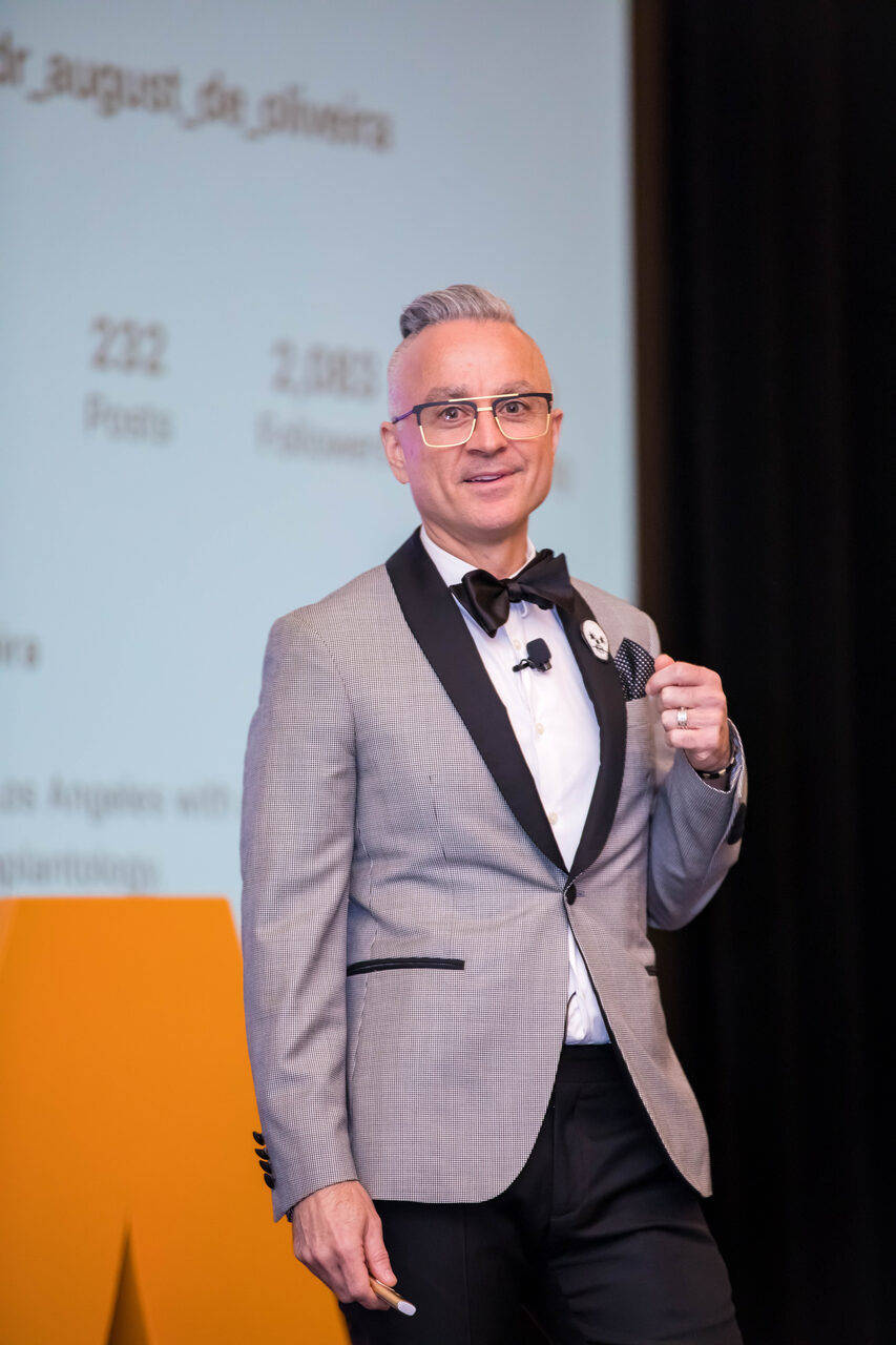 Dr. Joe Mehranfar speaking on the keynote stage at an implant dentistry conference